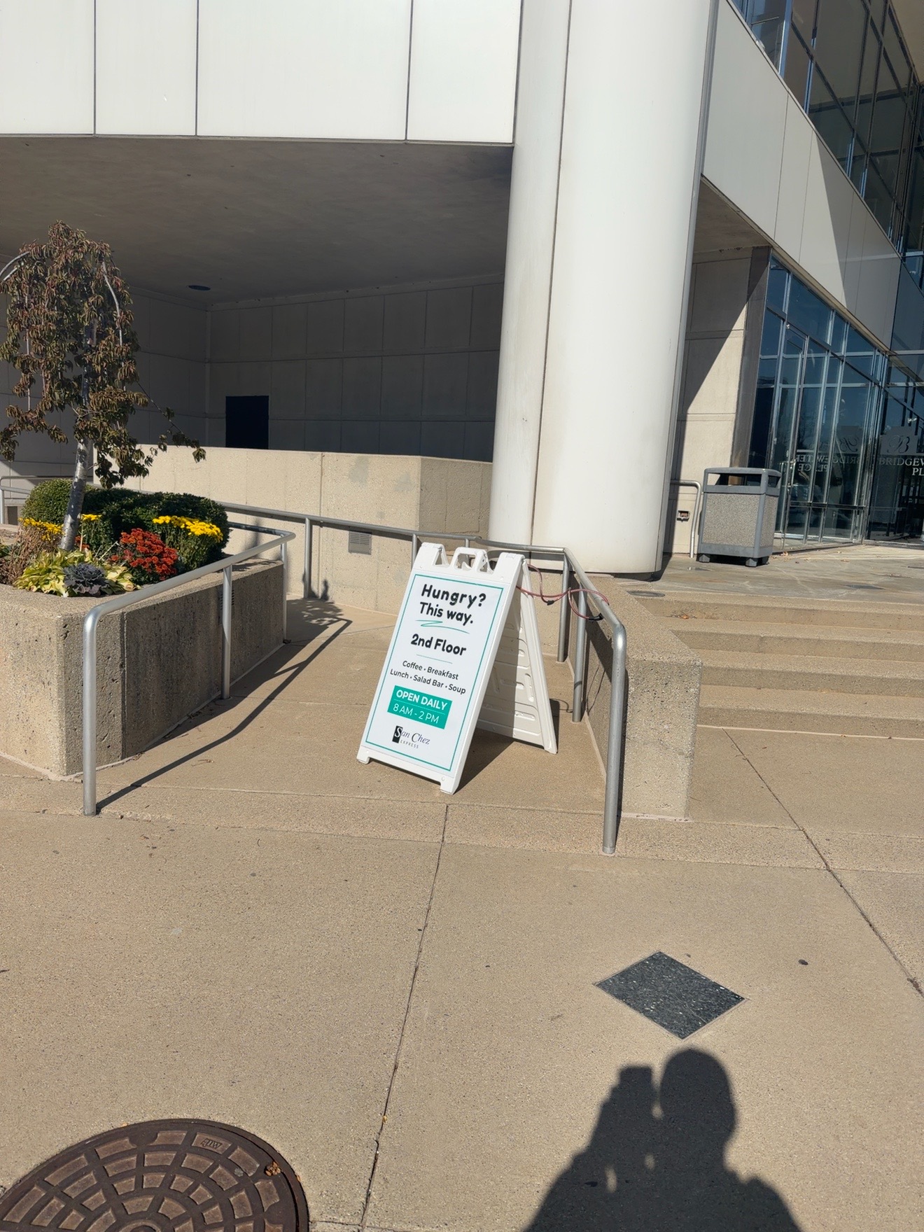 Sidewalk sign and photographer’s shadow