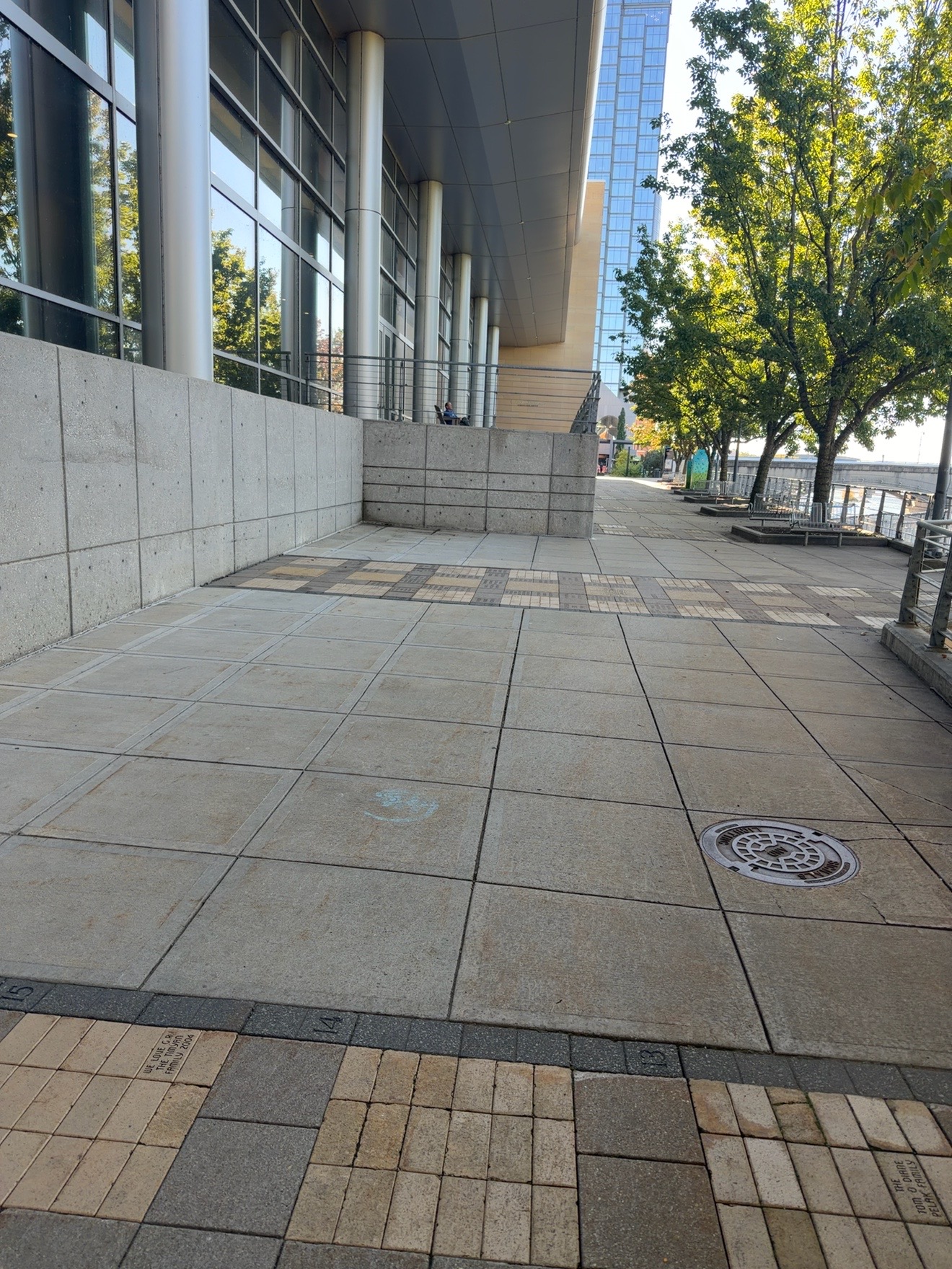 Long riverwalk beside a glass building